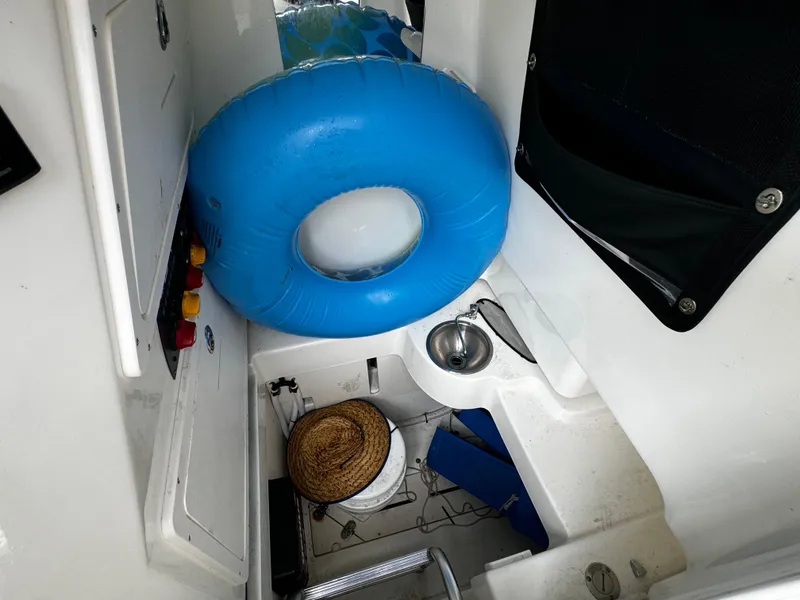 Slide: The Image of 2020 Mako 284 CC boat interior with blue inflatable ring and sink. - 30