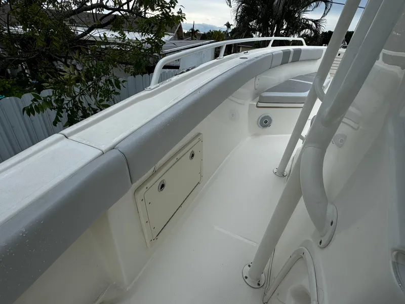 Slide: The Image of 2020 Mako 284 CC boat deck with white railing and storage compartment. - 34