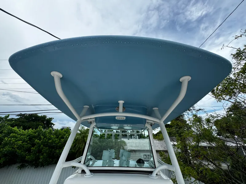 Slide: The Image of 2020 Mako 284 CC boat with blue T-top against cloudy sky. - 37