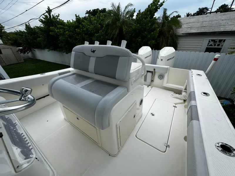 Slide: The Image of 2020 Mako 284 CC boat interior with seating and console, in a backyard setting. - 38