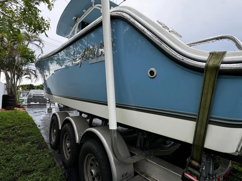 Slide: The Image of 2020 Mako 284 CC boat on trailer, blue hull, parked outdoors. - 9