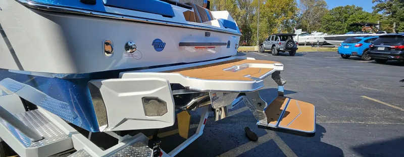 Slide: The Image of 2025 Malibu 25LSV boat with swim platform in a parking lot. - 10