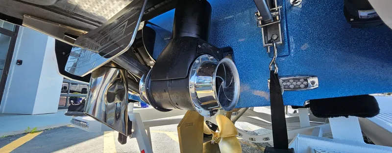 Slide: The Image of 2025 Malibu 25LSV boat propeller and hull detail in a showroom setting. - 11