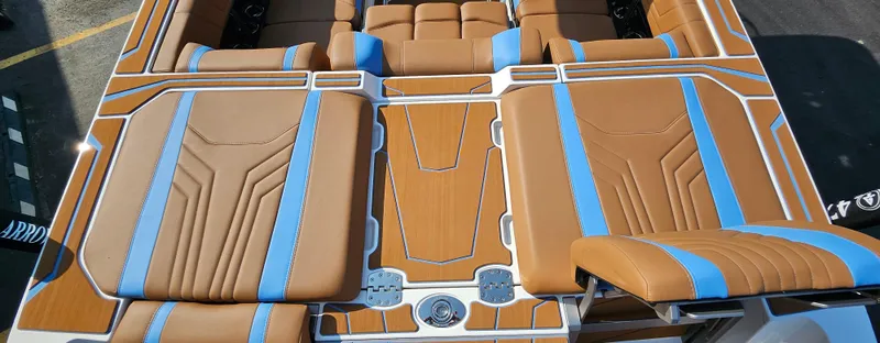 Slide: The Image of 2025 Malibu 25LSV boat interior with tan and blue upholstery, showcasing modern design. - 13