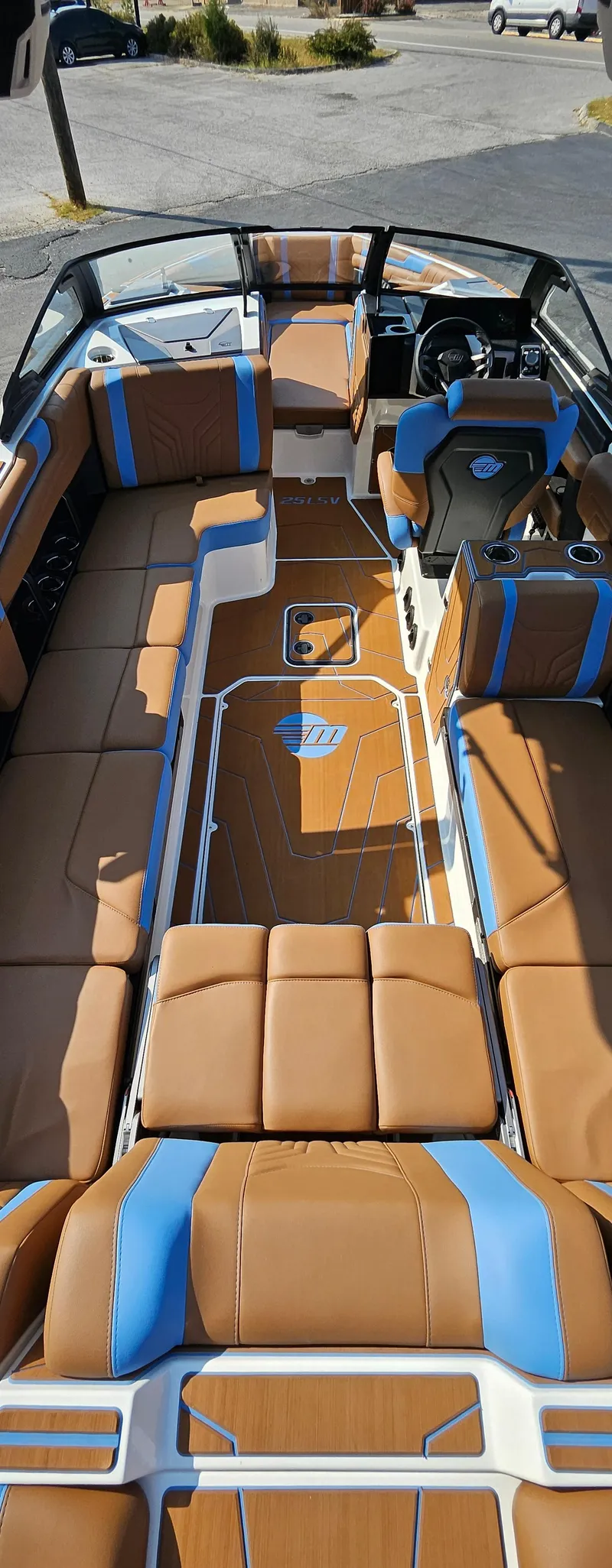 Slide: The Image of 2025 Malibu 25LSV boat interior with tan and blue seating, sleek design. - 14