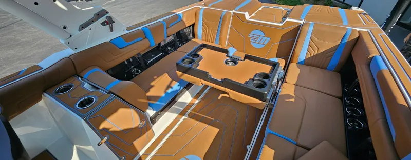 Slide: The Image of Luxurious interior of 2025 Malibu 25LSV boat with tan and blue seating. - 17