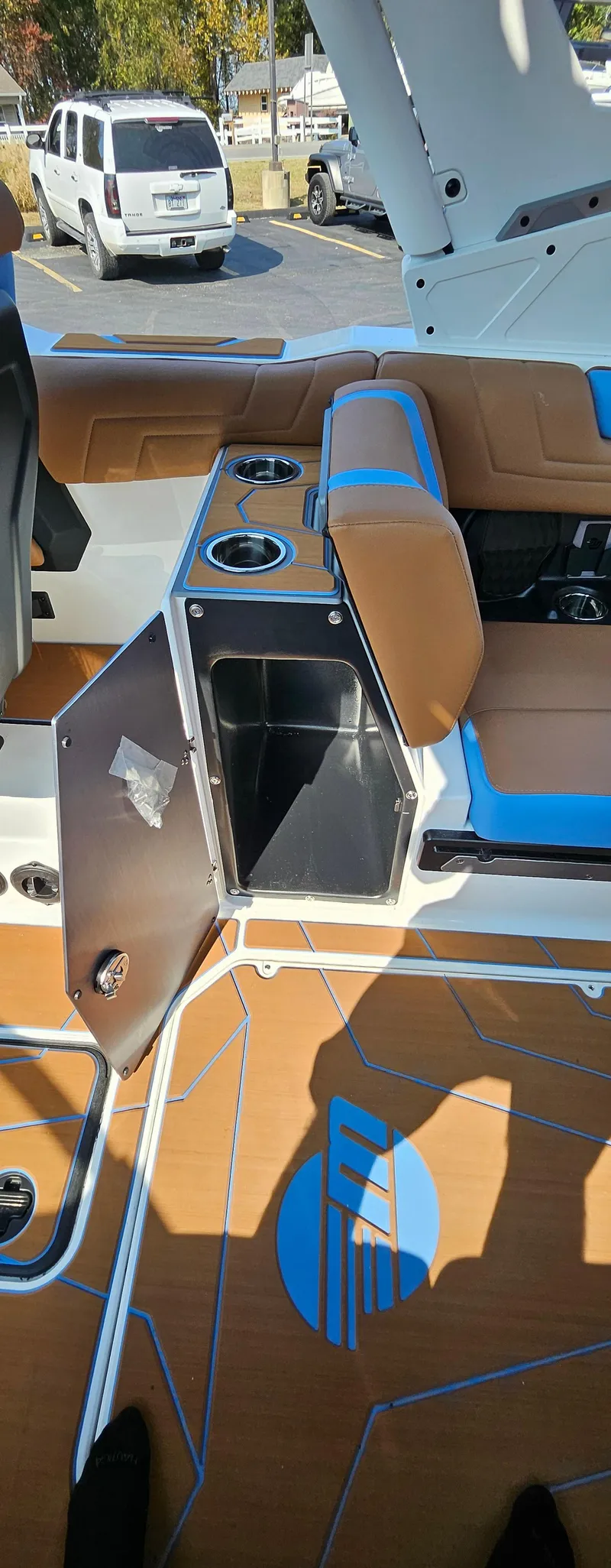 Slide: The Image of 2025 Malibu 25LSV boat interior with open storage compartment and cup holders. - 18