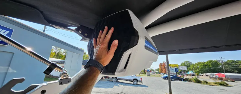 Slide: The Image of Hand touching speaker on 2025 Malibu 25LSV boat, outdoor setting. - 23