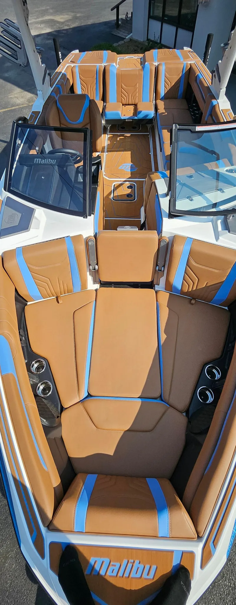 Slide: The Image of 2025 Malibu 25LSV boat interior with tan and blue seating, sleek design. - 26