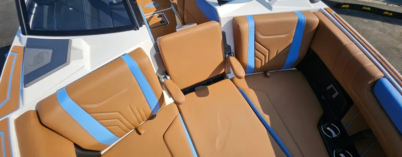 Slide: The Image of 2025 Malibu 25LSV boat interior with tan and blue seating. - 27