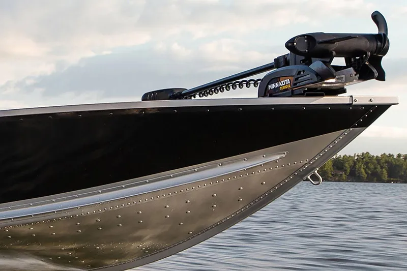 Slide: The Image of 2024 Alumacraft Classic 165 Tiller boat with Minn Kota trolling motor on a lake. - 20