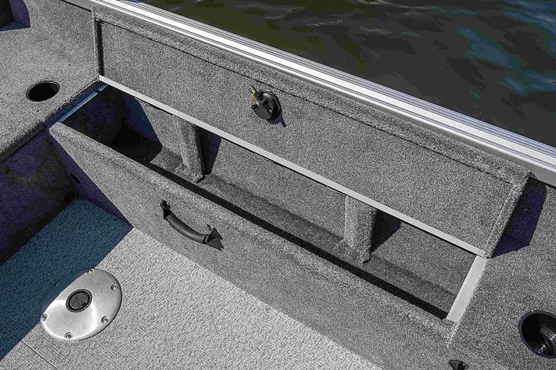 Slide: The Image of 2024 Alumacraft Classic 165 Tiller boat storage compartment with carpeted interior. - 24