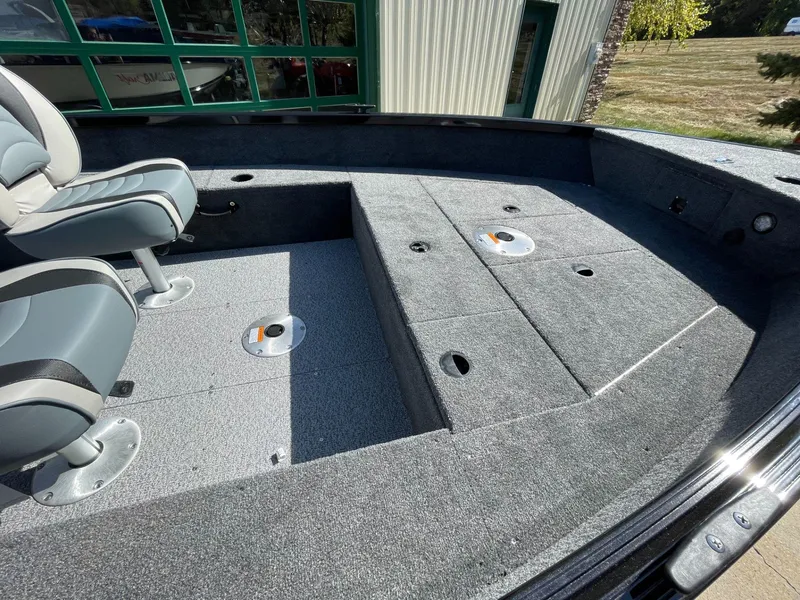 Slide: The Image of 2024 Alumacraft Classic 165 Tiller boat interior with seating and storage compartments. - 7