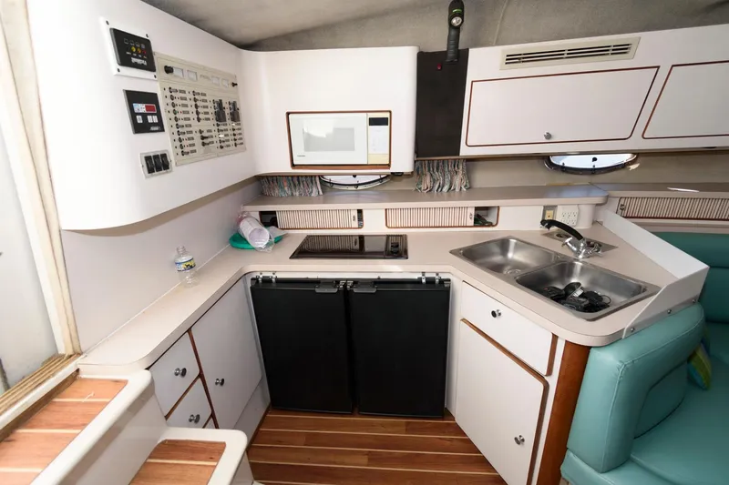 Slide: The Image of 1992 Regal Commodore 402 yacht interior kitchen with modern appliances and wood flooring. - 14