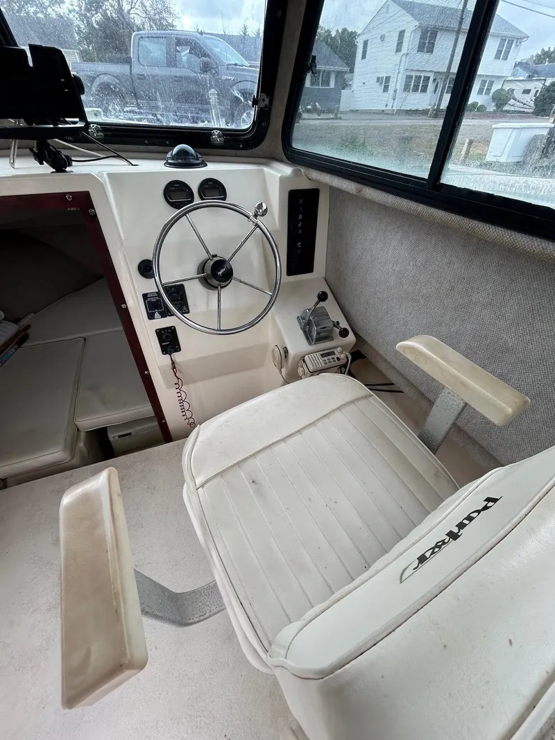 Slide: The Image of Interior of a 2001 Parker 2520 Modified Vee Sport Cabin boat with steering wheel and seat. - 22