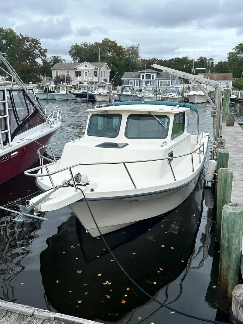 Slide: The Image of 2001 Parker 2520 Modified Vee Sport Cabin boat docked at a marina. - 3