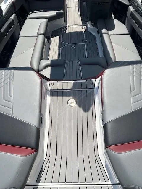 Slide: The Image of 2022 Nautique G23 boat interior with gray and black seating, red accents, and sleek design. - 11