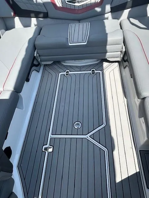 Slide: The Image of 2022 Nautique G23 boat interior with gray seating and deck flooring. - 12