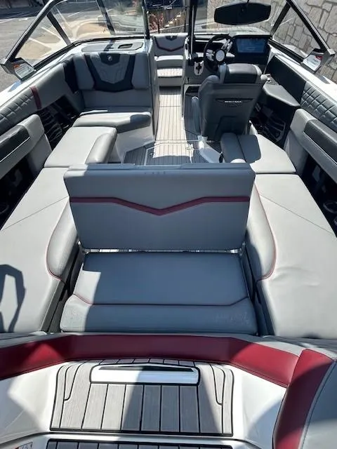 Slide: The Image of 2022 Nautique G23 boat interior with luxurious seating and modern dashboard. - 15