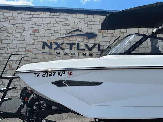 Slide: The Image of 2022 Nautique G23 boat at NXT LVL Marine dealership, side view. - 2