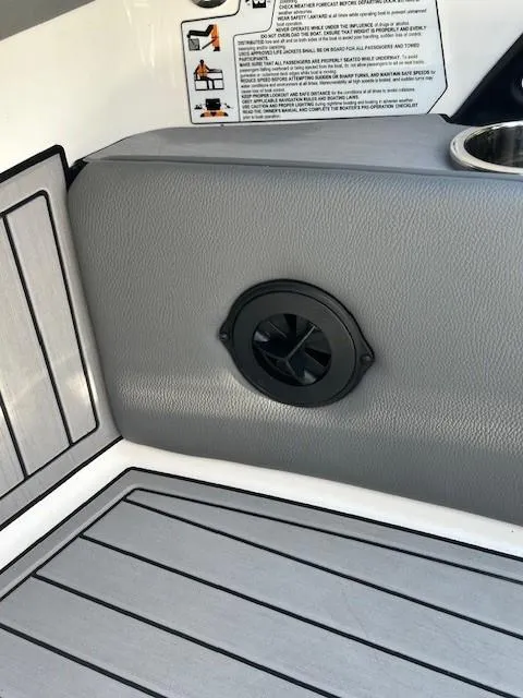 Slide: The Image of Interior detail of 2022 Nautique G23 boat, featuring gray upholstery and speaker. - 20