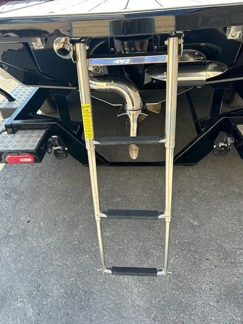 Slide: The Image of 2022 Nautique G23 boat ladder and exhaust system on a trailer. - 23