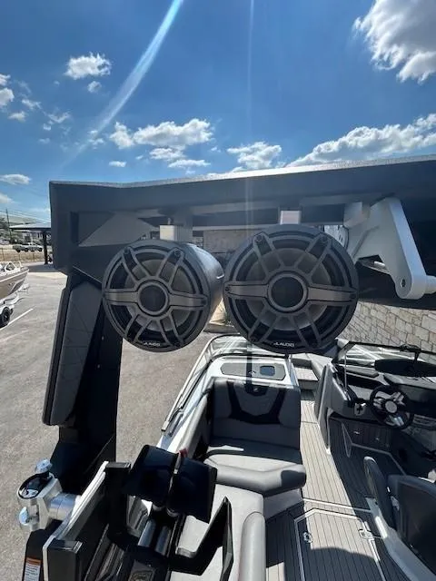 Slide: The Image of 2022 Nautique G23 boat with tower speakers under a sunny sky. - 24