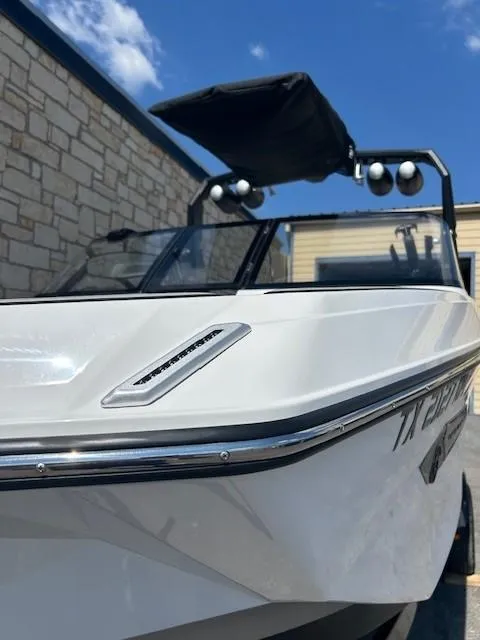 Slide: The Image of 2022 Nautique G23 boat with sleek design, docked under a clear blue sky. - 4