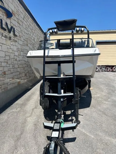 Slide: The Image of 2022 Nautique G23 boat on trailer, parked near a stone building under clear blue sky. - 5