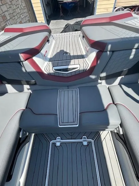 Slide: The Image of 2022 Nautique G23 boat interior with sleek gray and red seating design. - 7