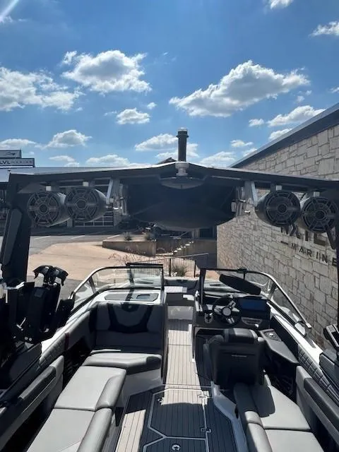 Slide: The Image of 2022 Nautique G23 boat interior with speakers, under a sunny sky. - 8