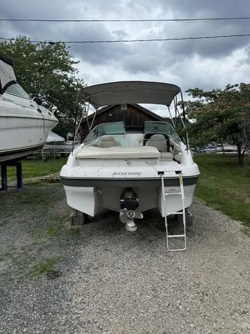 Slide: The Image of 2000 Four Winns Sundowner boat on land with ladder and canopy. - 3