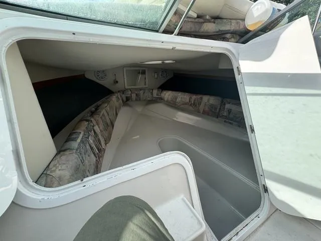 Slide: The Image of Interior cabin of 2000 Four Winns Sundowner boat, featuring cushioned seating and compact design. - 7