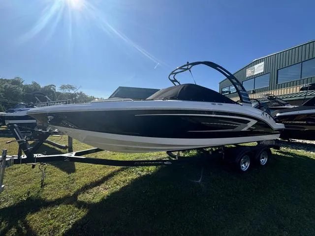 The Image of 2024 Chaparral 23 SSi OB boat on trailer, sunny day, grassy area. - 0