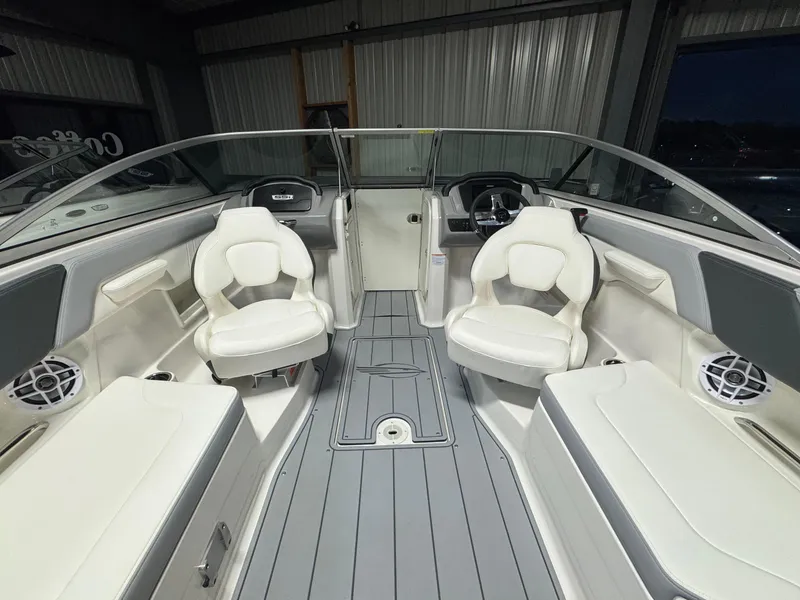 Slide: The Image of 2024 Chaparral 23 SSi OB boat interior with white seating and gray flooring. - 14
