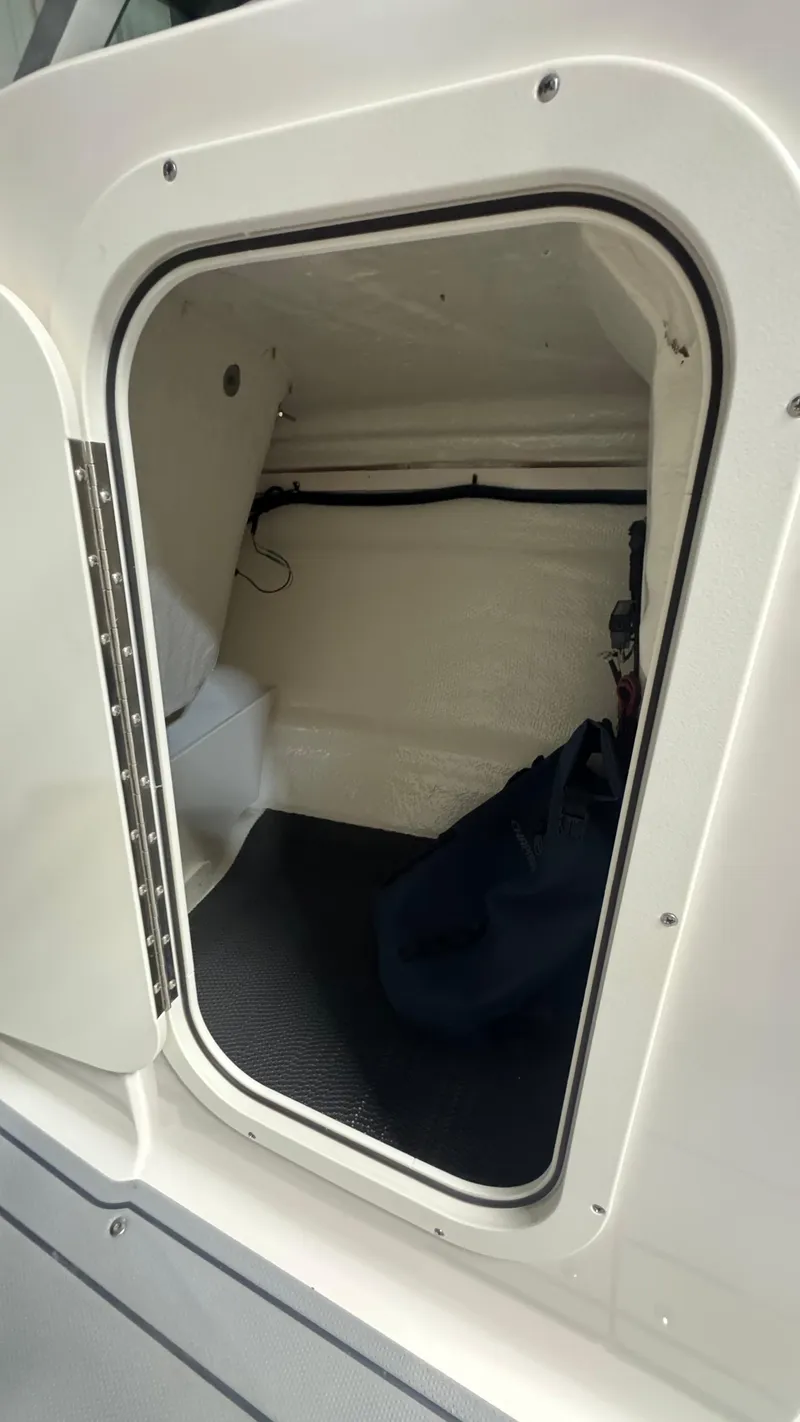 Slide: The Image of 2024 Chaparral 23 SSi OB boat storage compartment with open hatch. - 19