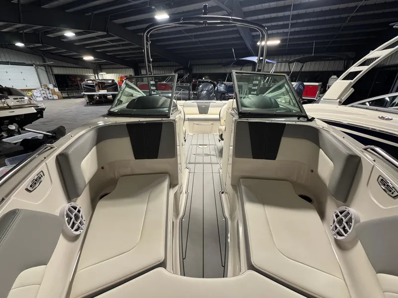 Slide: The Image of 2024 Chaparral 23 SSi OB boat interior with beige seating in a showroom. - 27