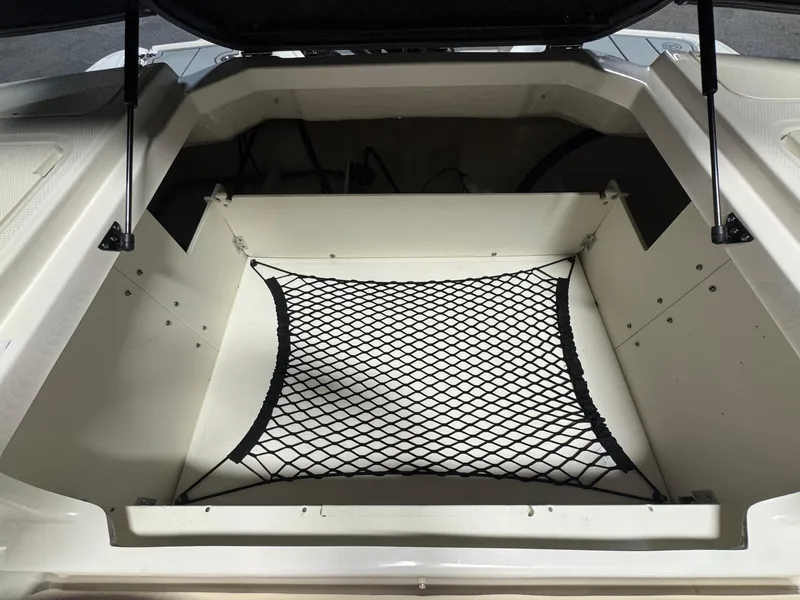 Slide: The Image of 2024 Chaparral 23 SSi OB boat storage compartment with netting. - 7