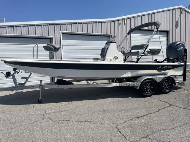 Slide: The Image of 2024 Avid 23 FSX boat on trailer, parked outside metal building. - 1