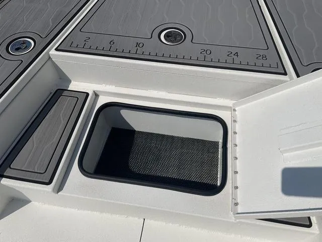 Slide: The Image of 2024 Avid 23 FSX boat deck with open storage compartment and measurement markings. - 10