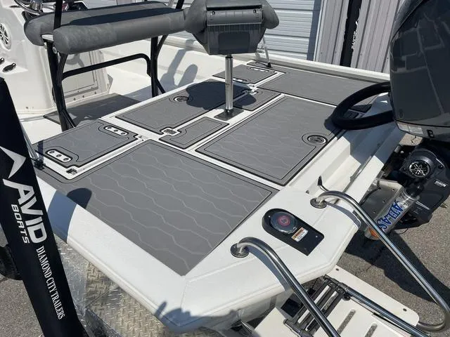 Slide: The Image of 2024 Avid 23 FSX boat deck with gray non-slip surface and seating. - 23