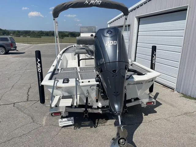Slide: The Image of 2024 Avid 23 FSX boat with Yamaha 200 engine, parked near a garage. - 3