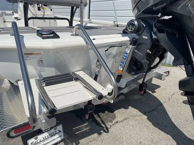 Slide: The Image of 2024 Avid 23 FSX boat with motor and swim ladder, docked at marina. - 4