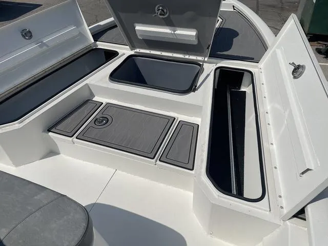 Slide: The Image of 2024 Avid 23 FSX boat storage compartments with open hatches, showcasing ample space. - 8