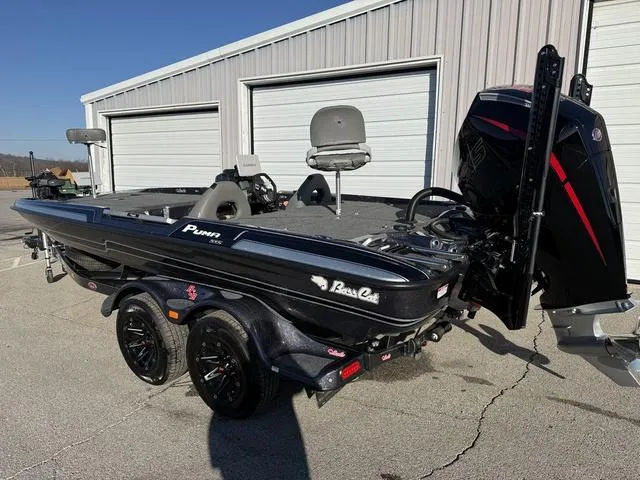 Slide: The Image of 2024 Bass Cat Puma STS boat with trailer, parked outside a garage. - 3