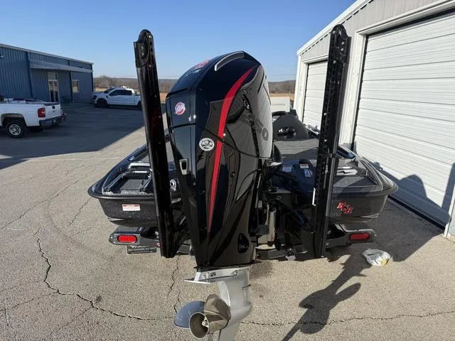 Slide: The Image of 2024 Bass Cat Puma STS boat with powerful outboard motor, parked near garage. - 4