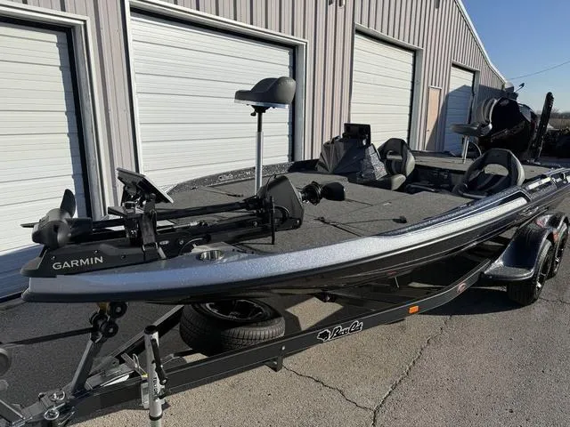 Slide: The Image of 2024 Bass Cat Puma STS boat parked outside a metal garage. - 5