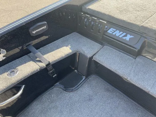 Slide: The Image of 2024 Phoenix 920 Elite boat interior with gray carpet and storage compartments. - 11