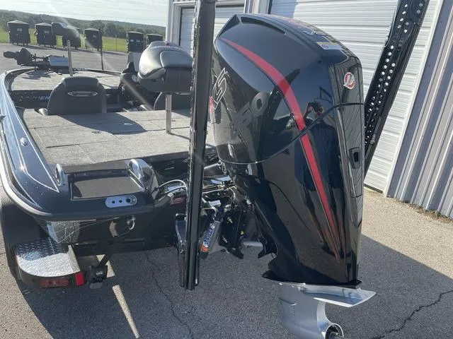 Slide: The Image of 2024 Phoenix 920 Elite boat with powerful outboard motor, parked near a garage. - 4