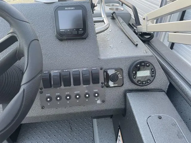 Slide: The Image of 2024 SeaArk Easy 200 boat dashboard with Suzuki controls and switches. - 13
